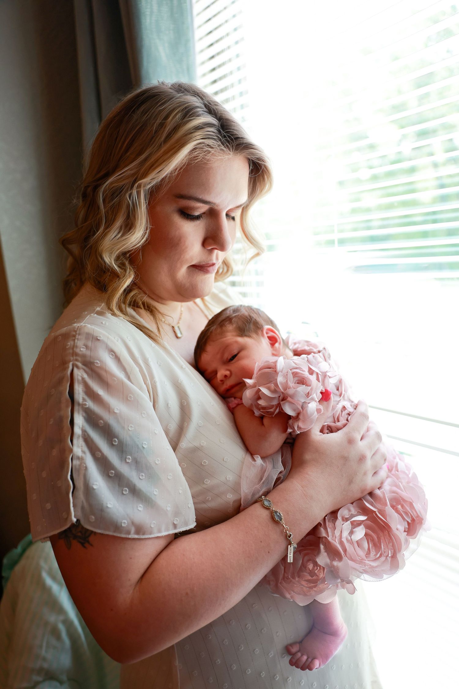 A tender moment captured as a parent cradles a newborn baby in home new session Carlsbad, Roswell, Hobbs NM