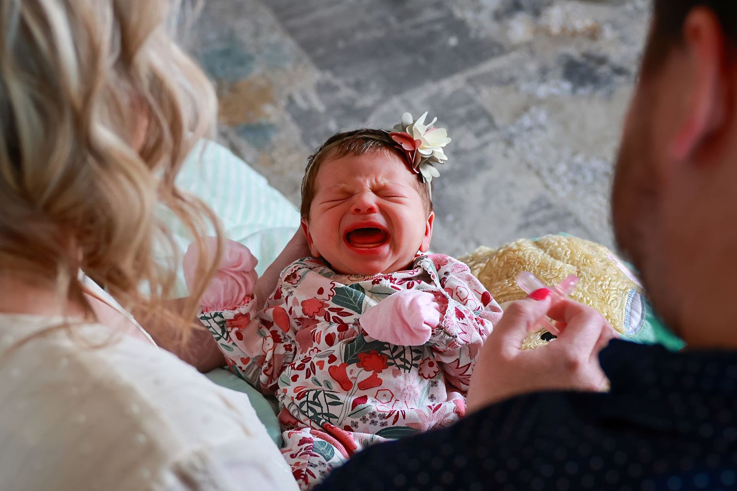 A crying baby wearing Carlsbad Roswell Artesia Hobbs New Mexico NM lifestyle in home newborn pictures