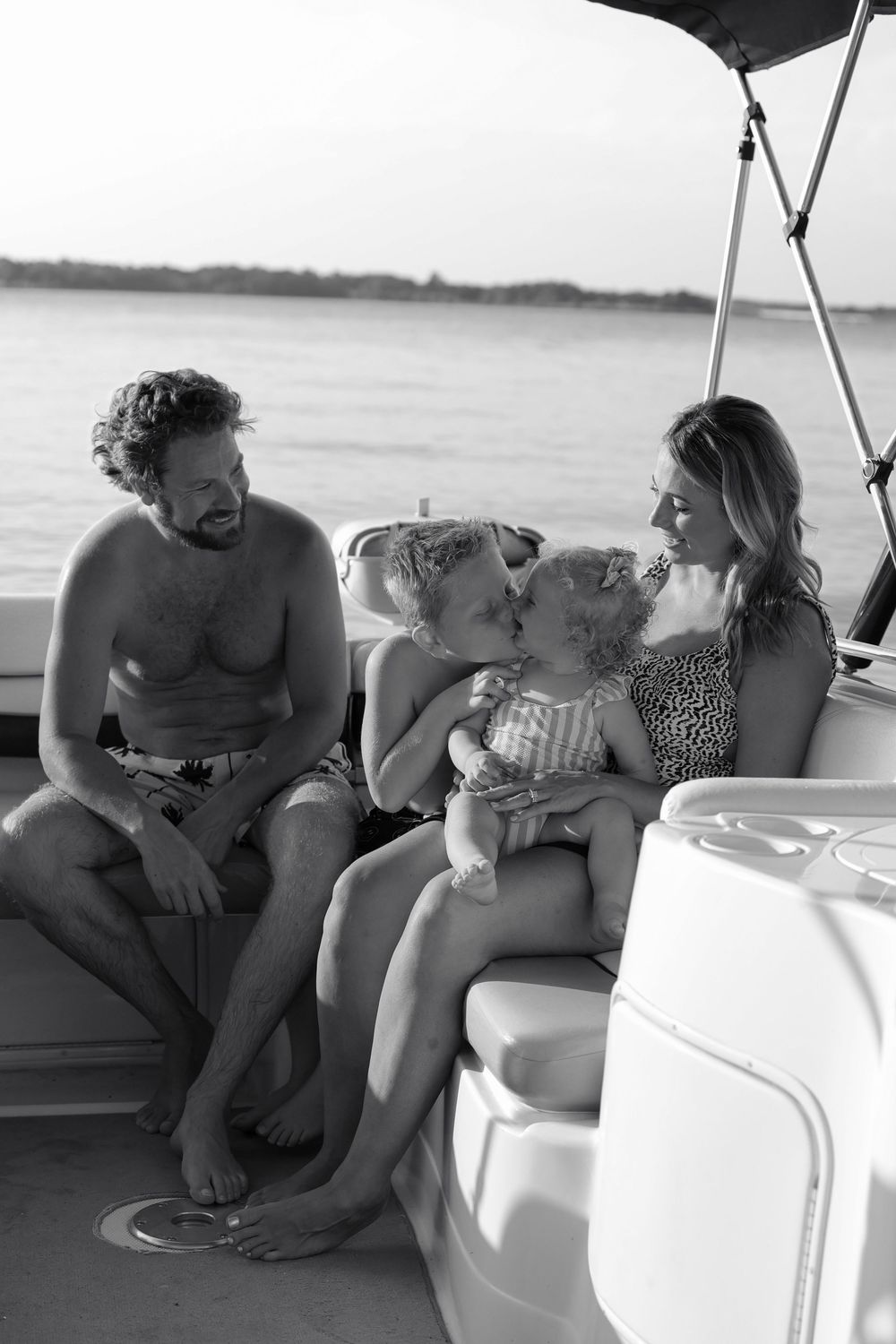 Family enjoying a relaxing moment together on a boat during a summer day.