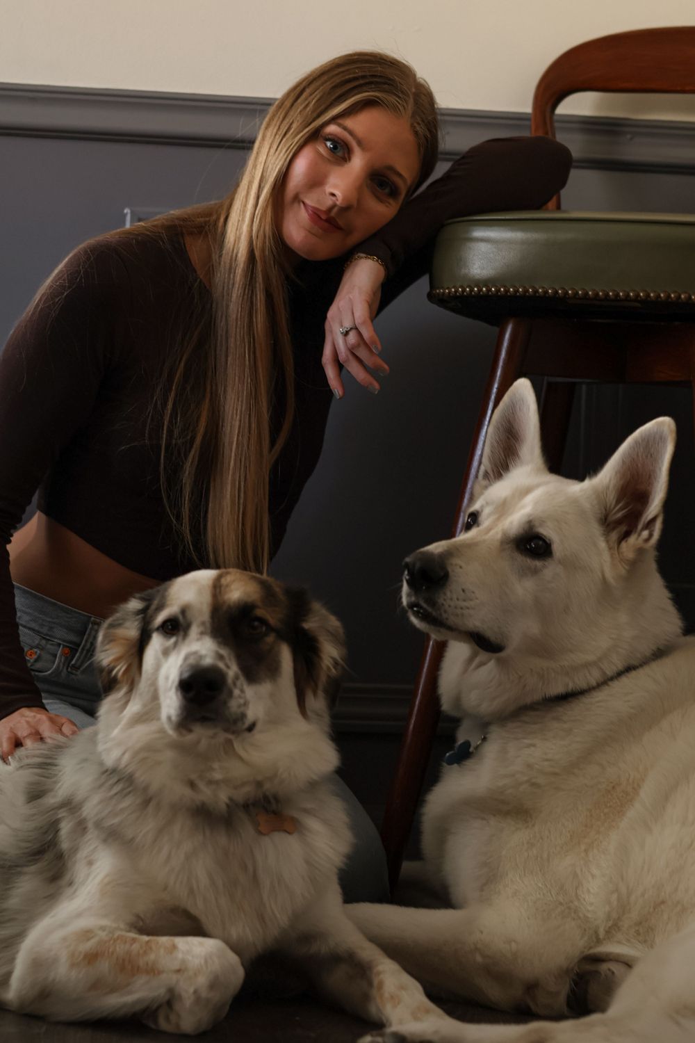 Heartwarming moments with a fluffy white dog lounging on dark furniture.