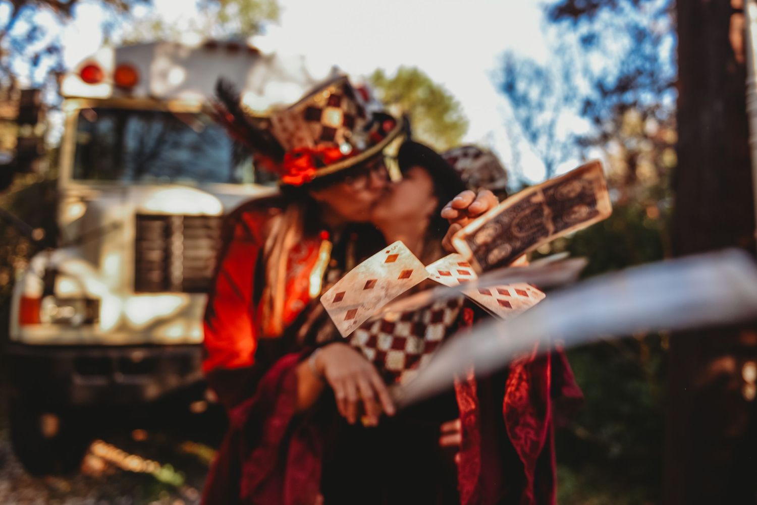 A musician in a red jacket plays guitar at an outdoor venue in a blurred artistic photograph.