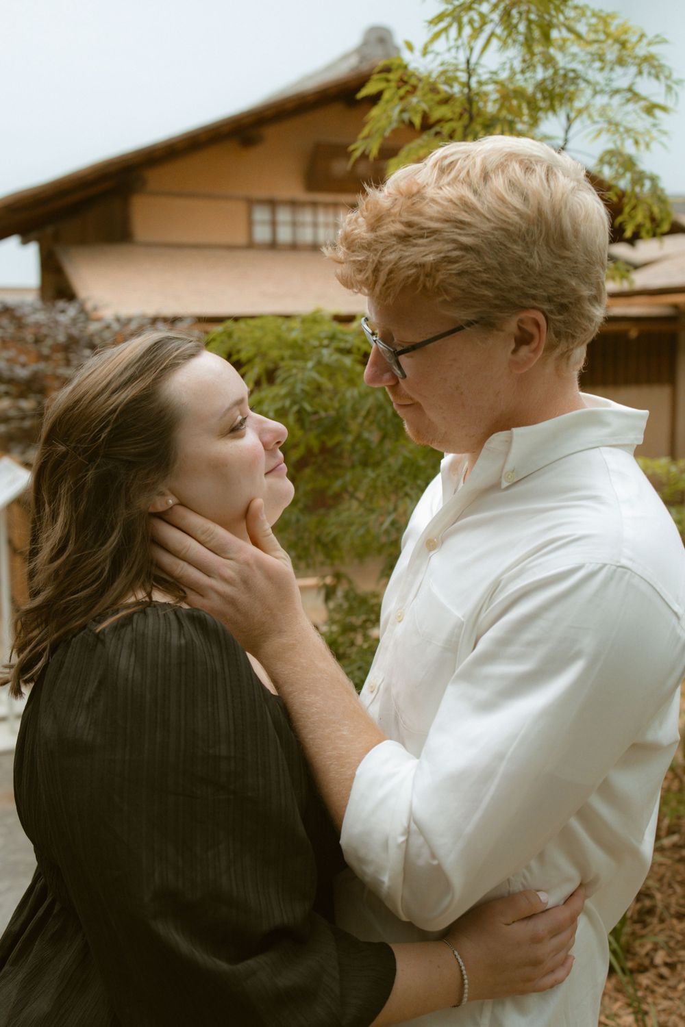 A woman and man looking at each other romantically while the man holds her face