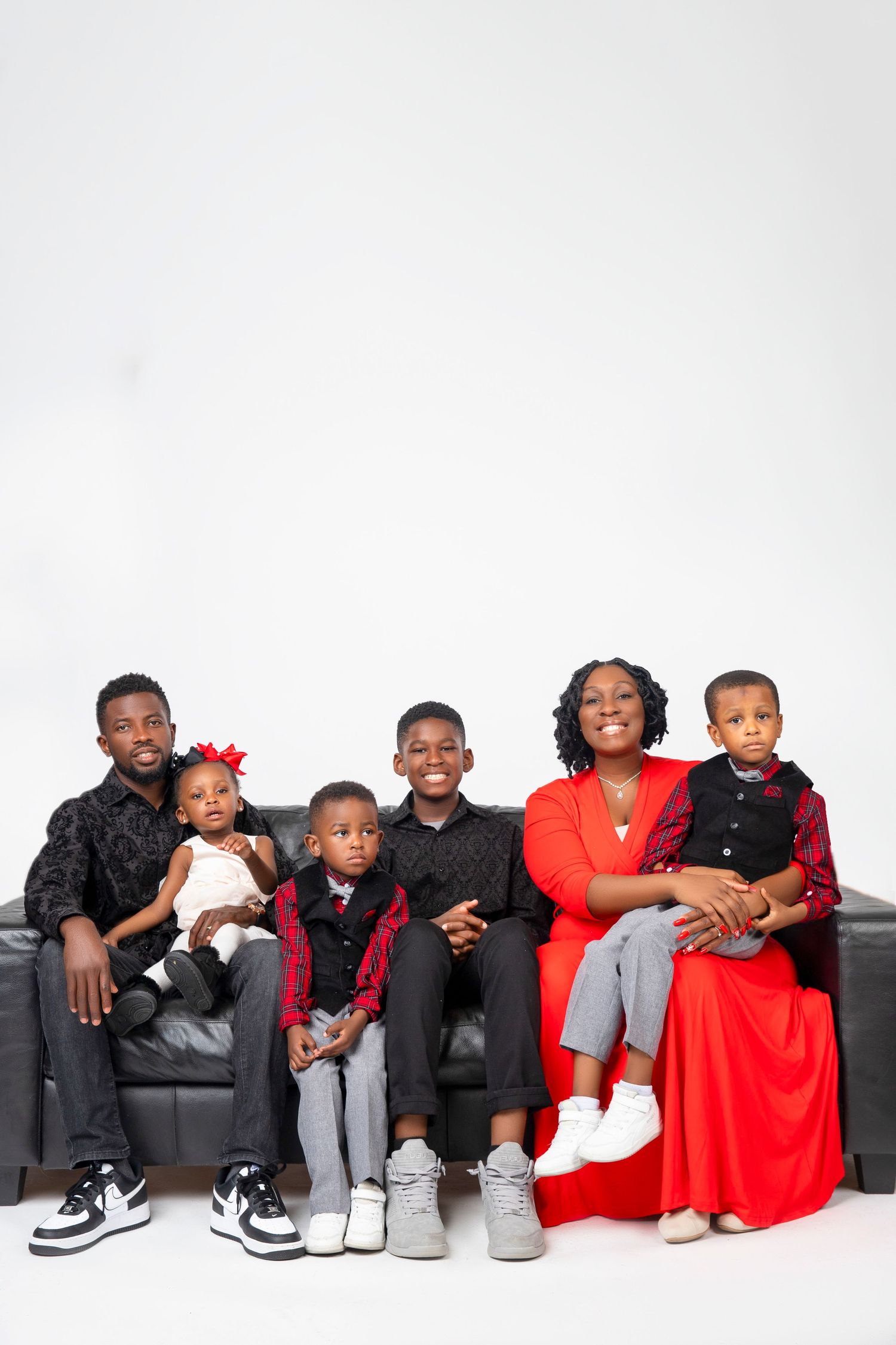 Modern family portrait with coordinated outfits against white background.