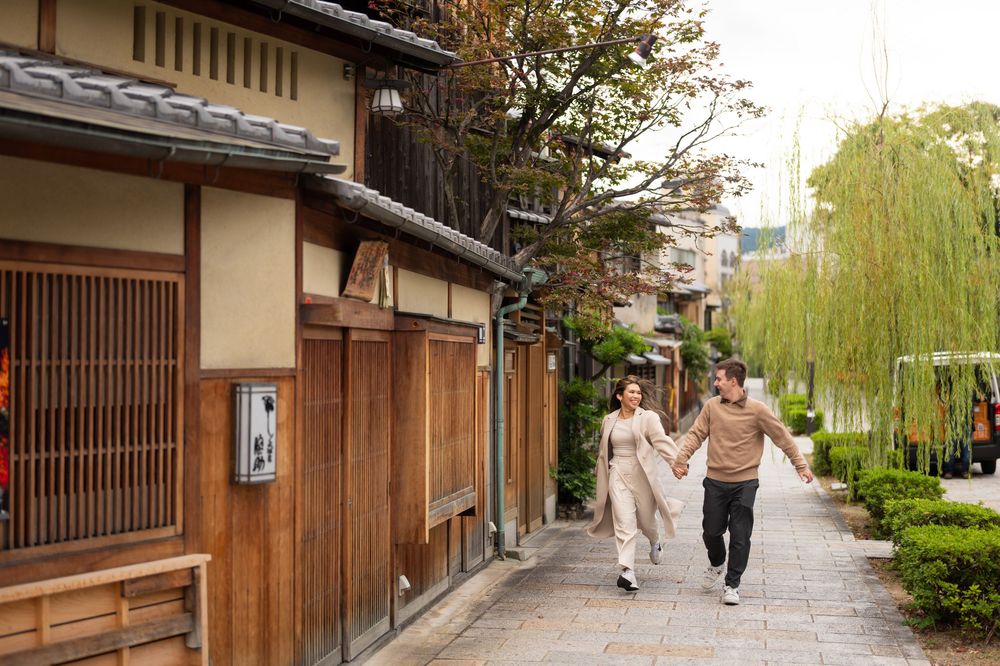 Happy couple holding hands and running along a picturesque traditional street in Kyoto, Japan.