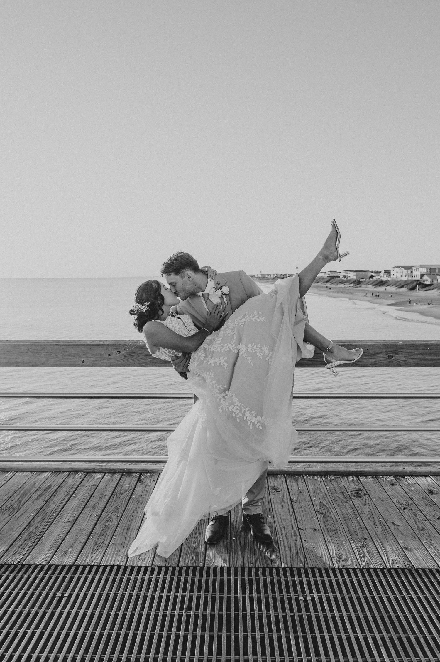 A romantic black and white sequence of a couple dancing on a boardwalk with dramatic dips and poses.