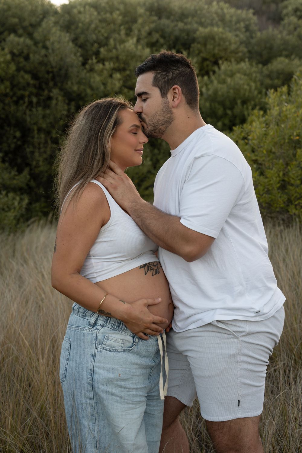 Romantic maternity couple photoshoot in Wollongong’s long grass, celebrating new beginnings.
