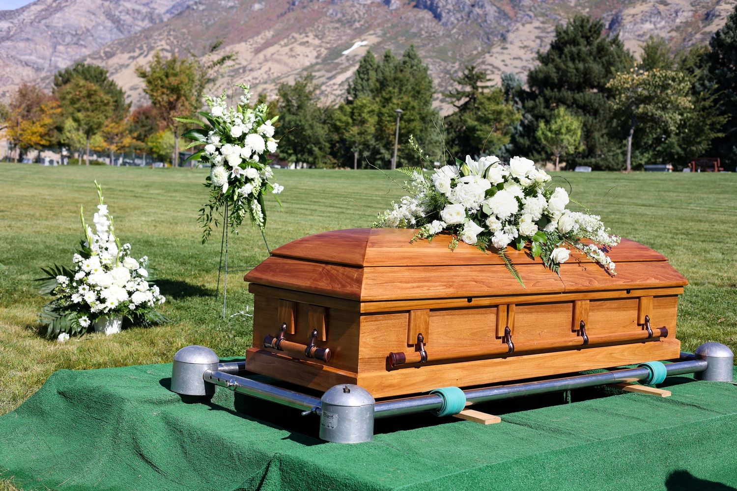 Wooden casket with floral arrangement at cemetery in Utah