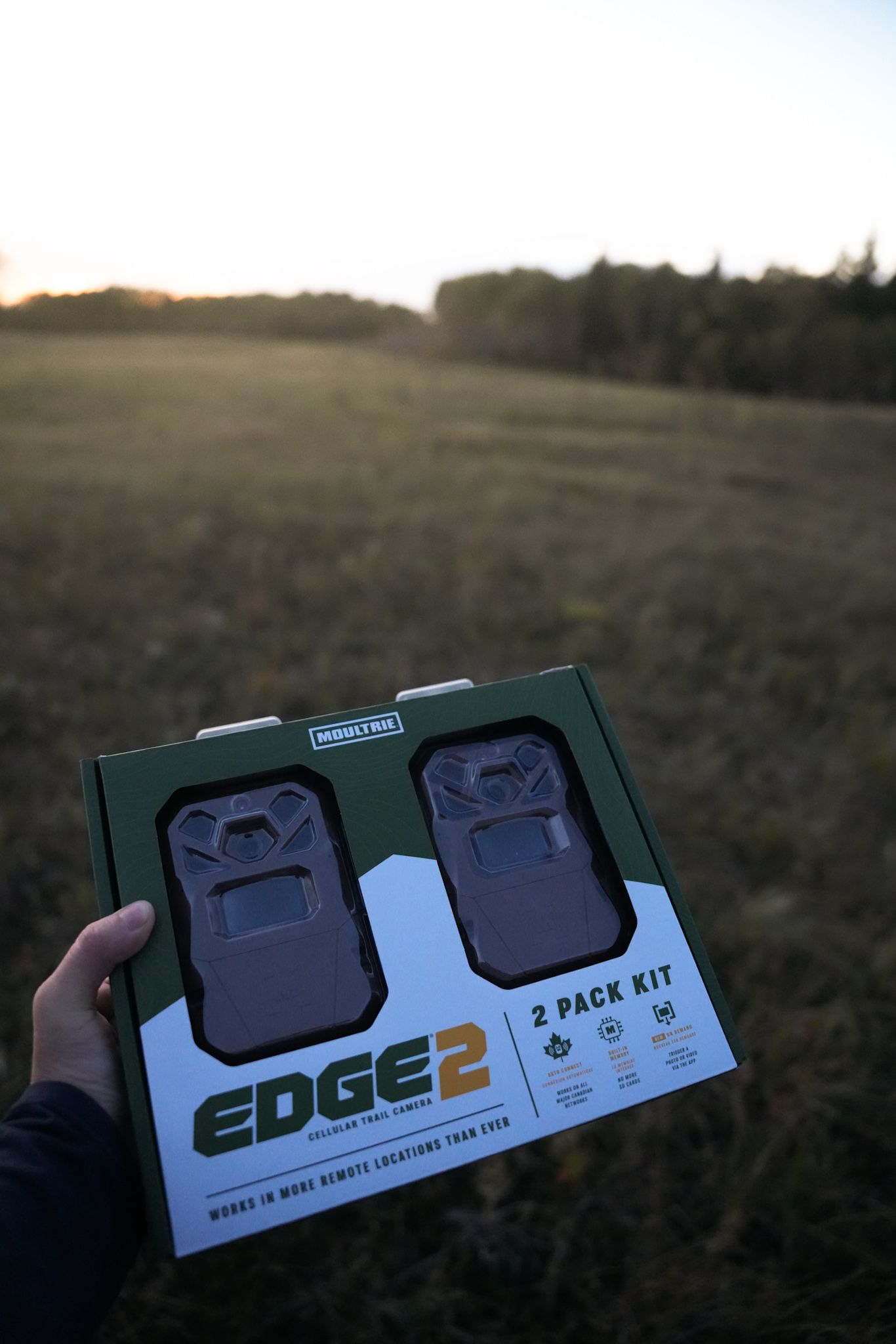 A series of shots showing an Edge 2 product box held against a sunset landscape background.