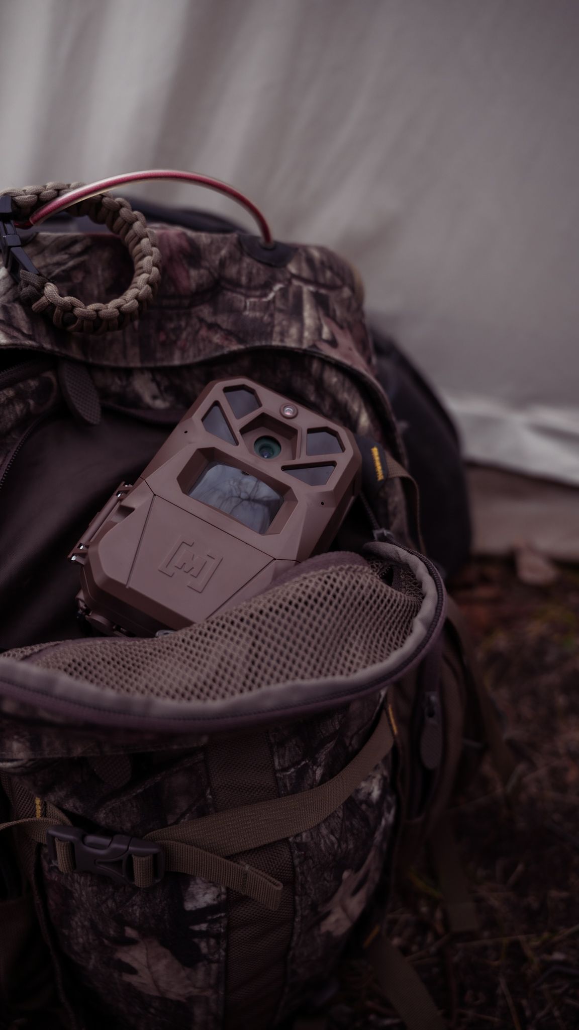 A camouflage patterned hunting gear or equipment shown in detailed close-up shots.