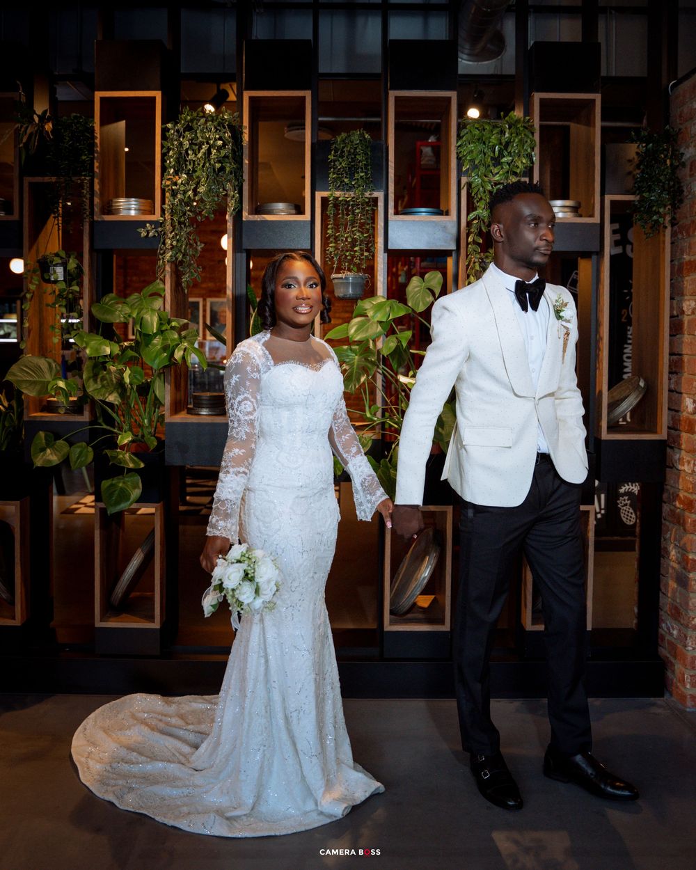 A wedding couple dances and poses in a series of romantic shots in front of a venue with framed photos and greenery.