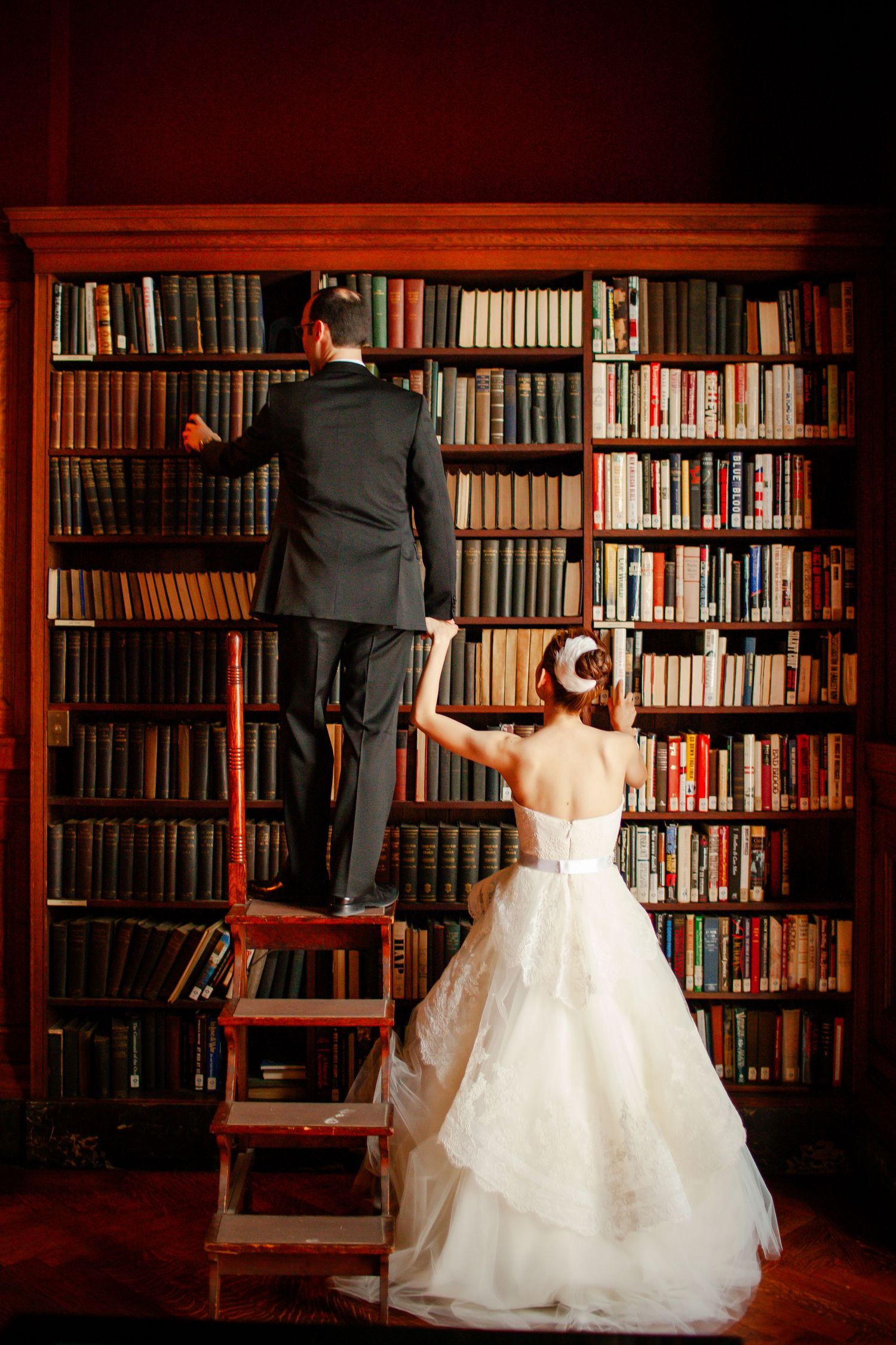 Wedding photography sequence showing silhouettes against warm-lit library bookshelves in an elegant setting.