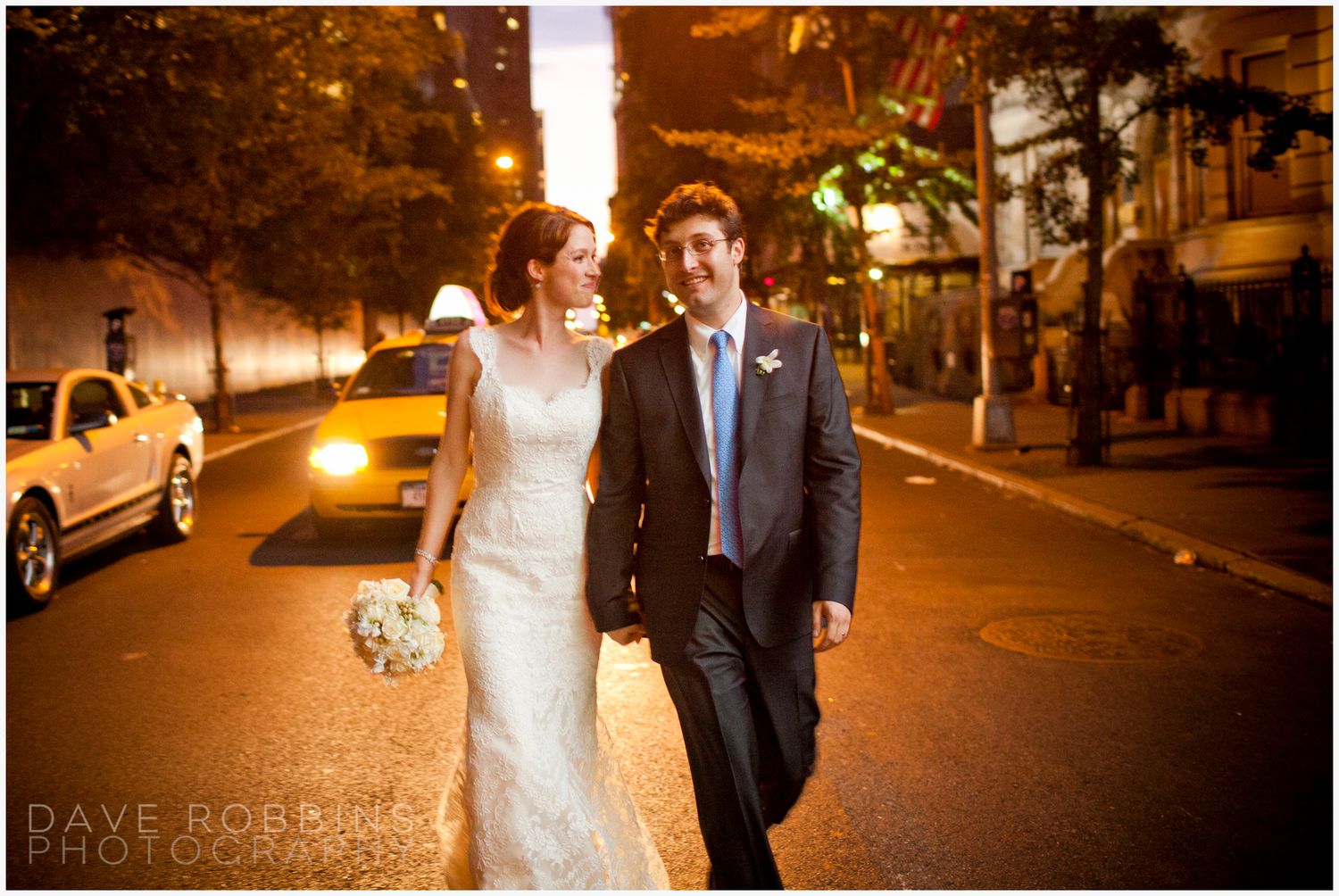 Romantic nighttime wedding photos of couple walking along city streets.
