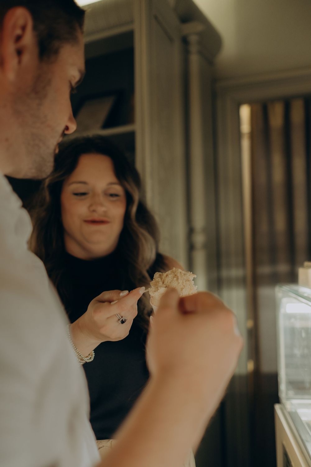 a couple trying ice cream in ice cream shop in Gamla Stan while being captured by cinematic vacation photographer for couples in Stockholm