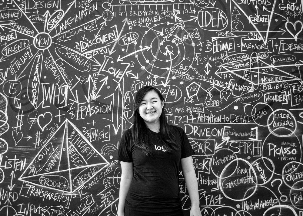 Black chalkboard wall covered with mathematical formulas and scientific drawings.
