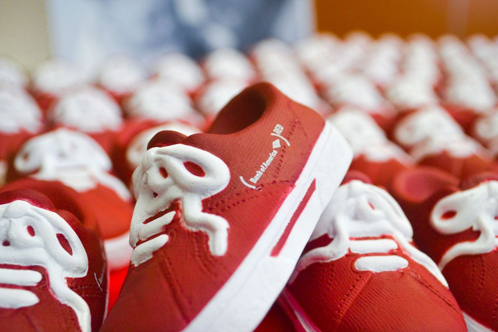 Close-up of red football helmets lined up in a row showing white details.