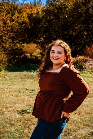 A sequence of autumn outdoor portraits showing a person in a brown top and blue jeans posing playfully against fall foliage.