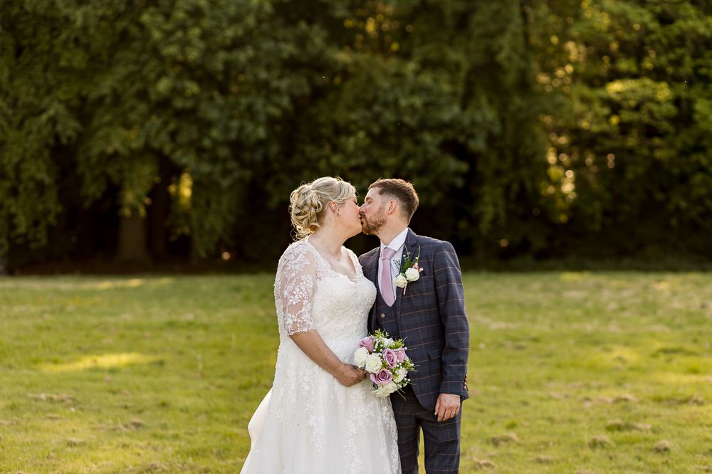 Elegant wedding photos taken against a backdrop of trees at sunset.