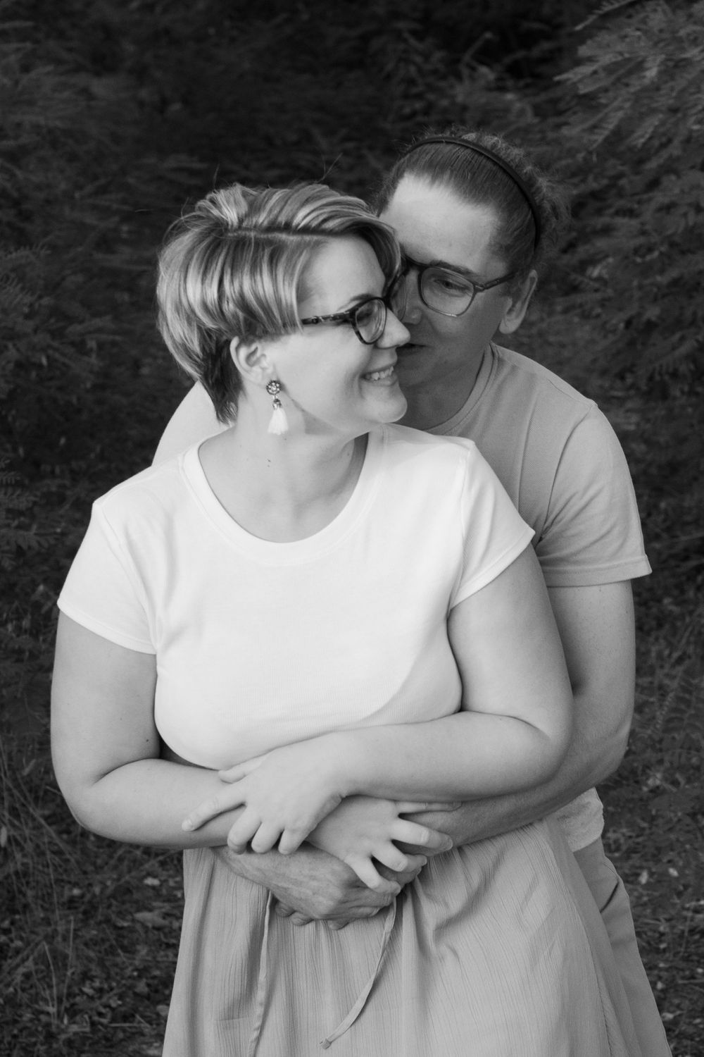 A romantic black and white photo series showing a couple embracing tenderly against a dark background.