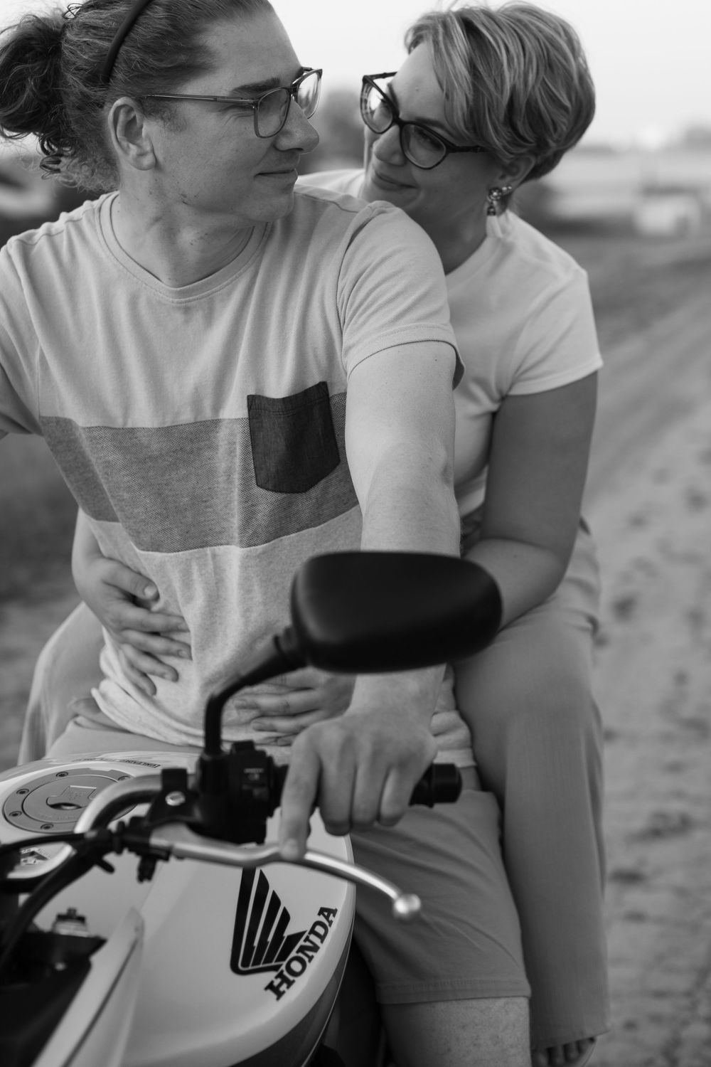 Couple sharing an intimate moment on a motorcycle, with close-up shots showing affectionate gestures.