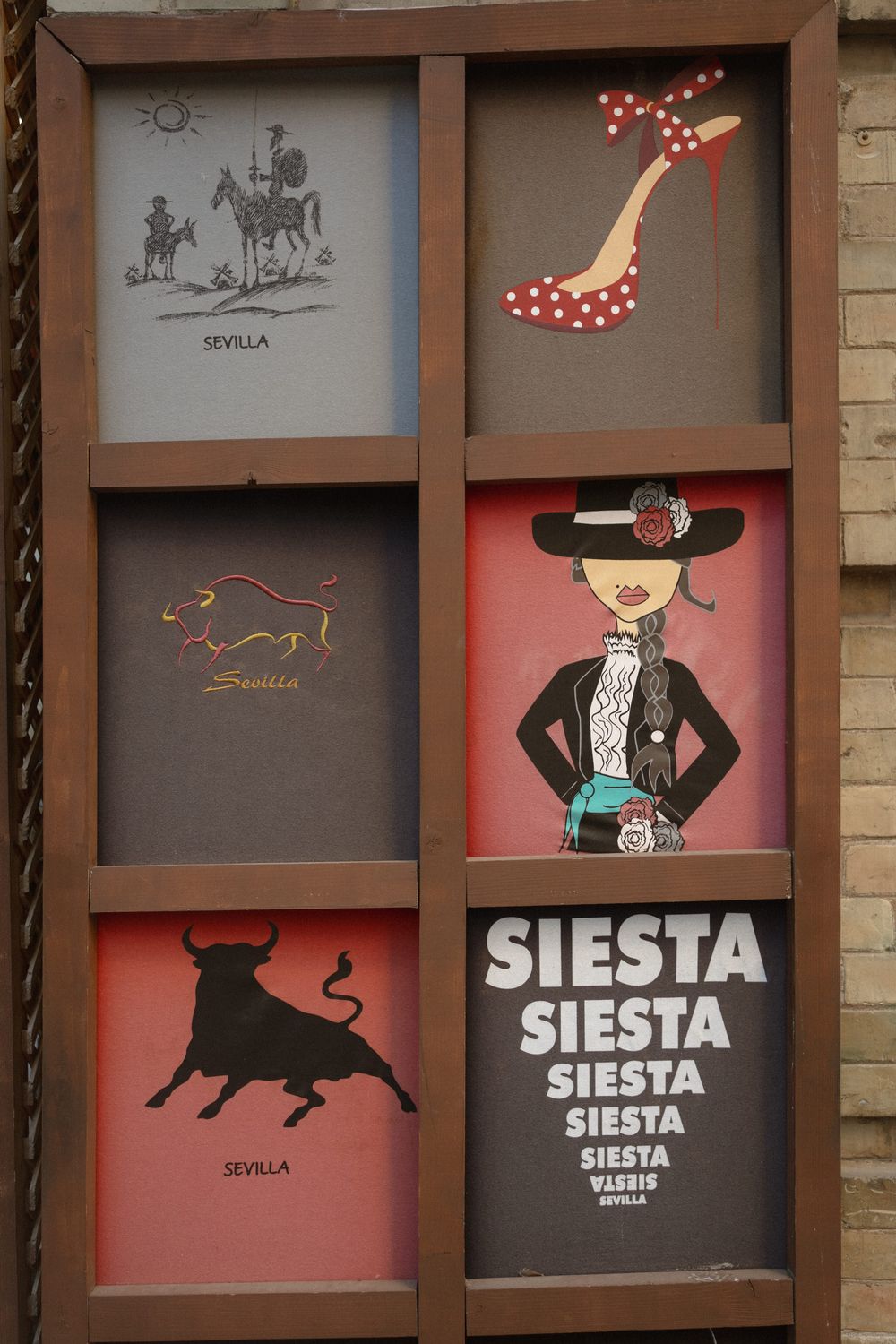 Spanish-themed decorative wall display featuring silhouettes of flamenco, bull, and Sevilla motifs in pink and gray panels.