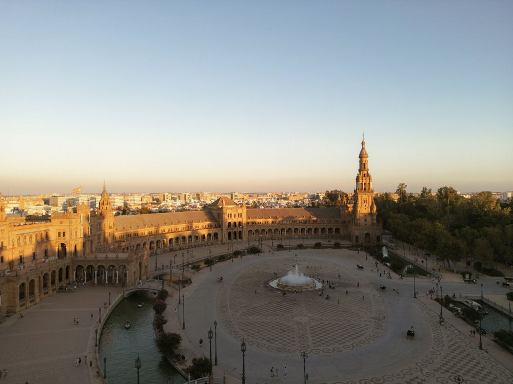 A panoramic view of Krakow's historic market square at sunset with the iconic St. Mary's Basilica in the background.