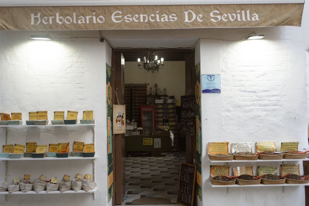 A panoramic view of a traditional Spanish ice cream shop interior with wooden shelves displaying various dessert items.