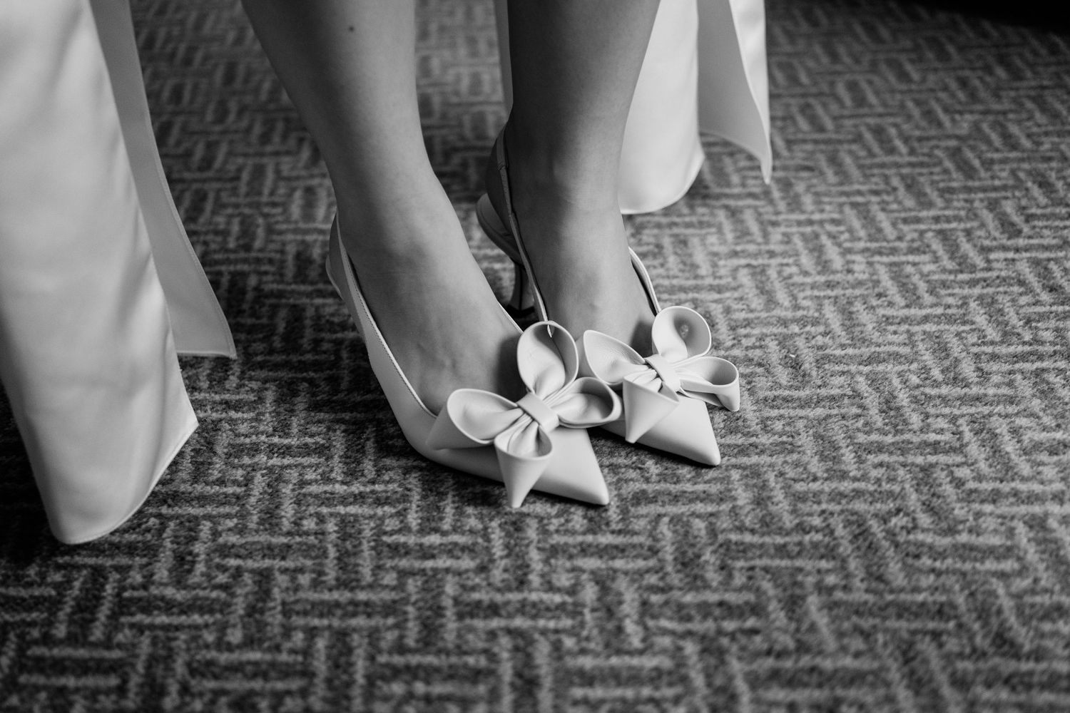 Black and white photo sequence showing feet in high heels walking across a patterned carpet.