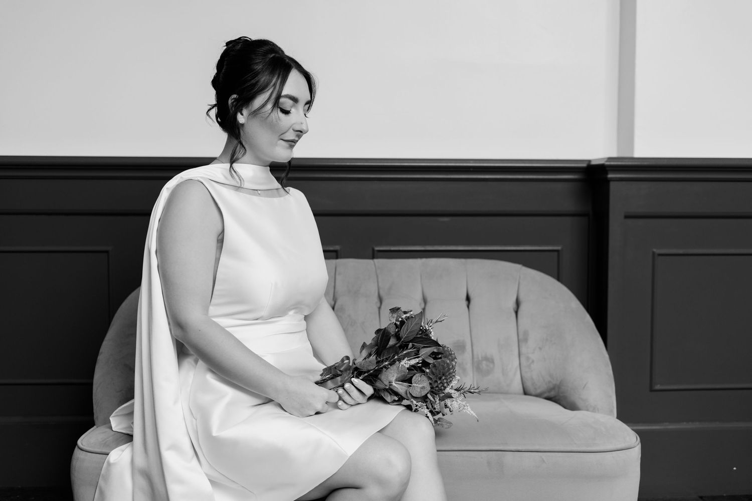 A series of black and white photos showing a person in a white dress posing on a gray couch.