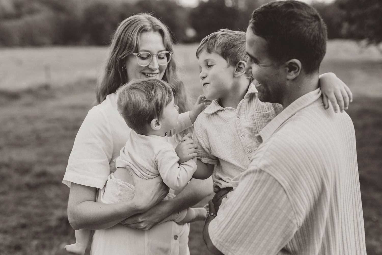 A series of romantic black and white photographs showing tender moments between couples in an outdoor setting.