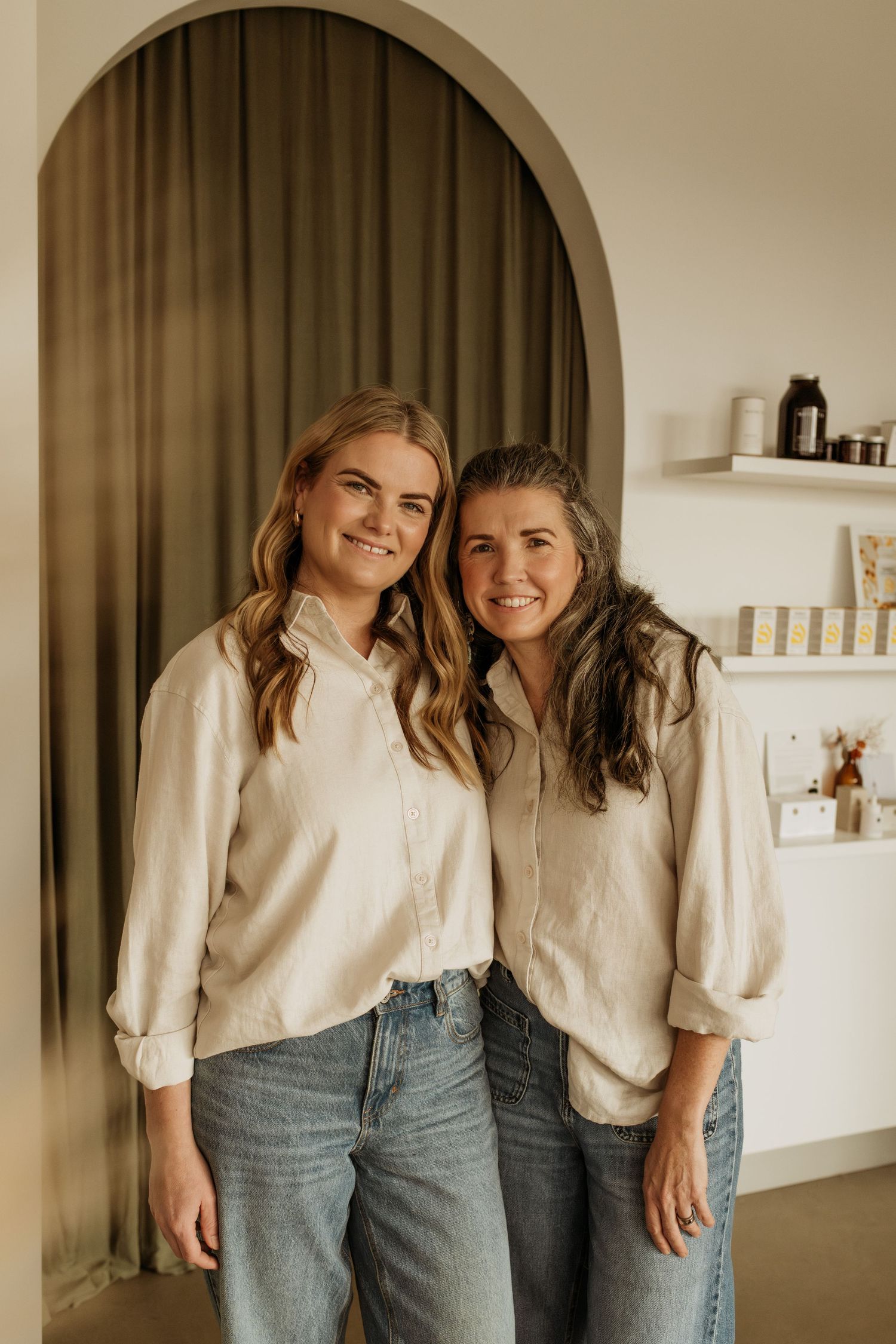 Banksia Skin Co Branding Session, two beauty therapists smiling at the camera in front of their natural shop products.
