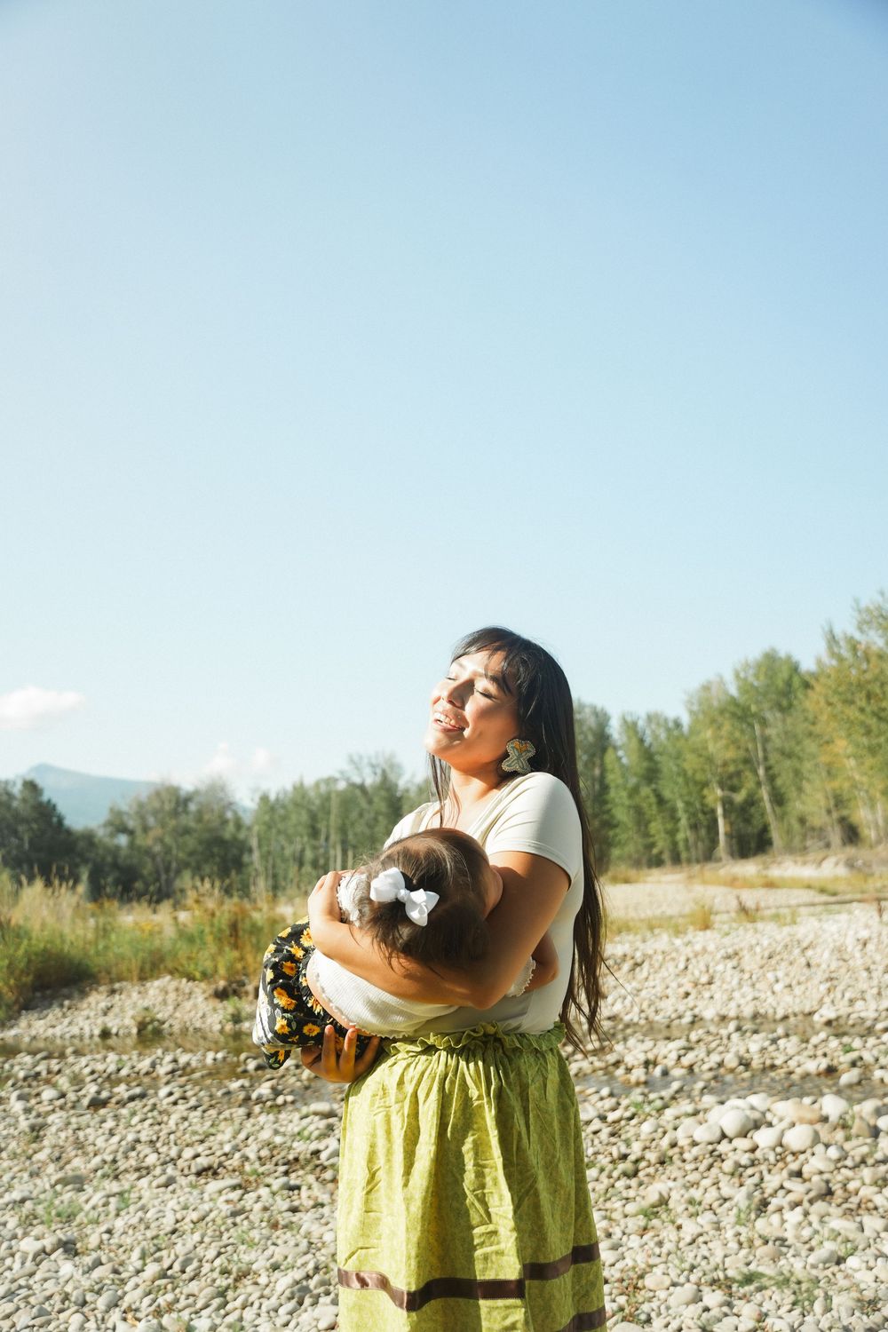 A person in a yellow dress relaxes on rocky terrain while enjoying the warm sunlight and natural surroundings.