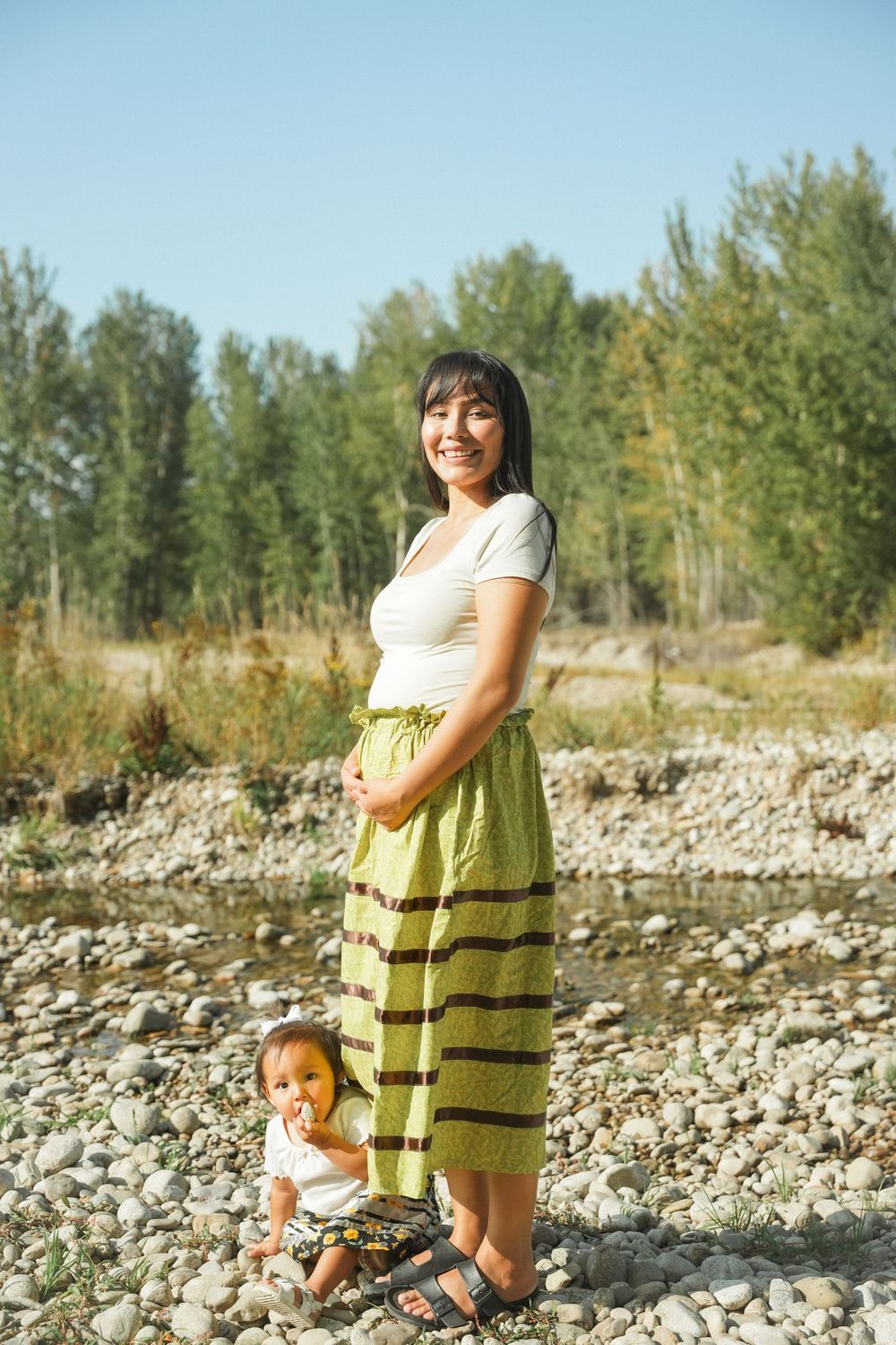 A sequence of three photos shows a joyful moment on a rocky riverbank with someone wearing a lime green dress.