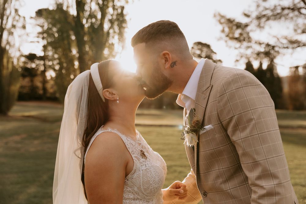 A couple shares romantic sunset moments in a garden setting during their wedding celebration.