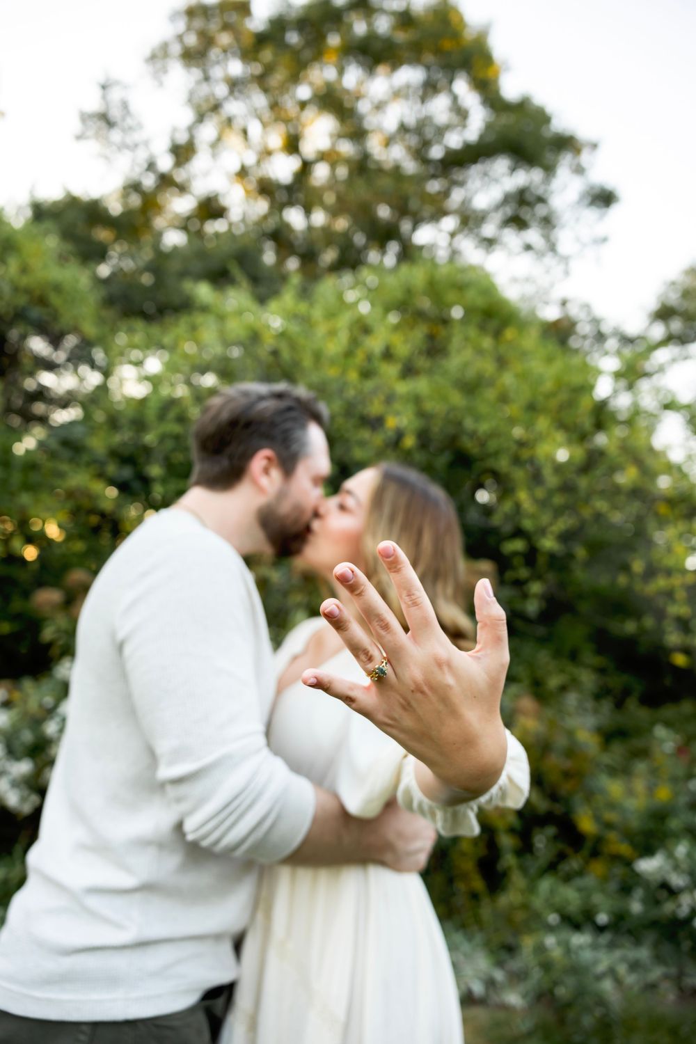 A couple in white clothing share a romantic moment in a garden setting showing a progression of their embrace.