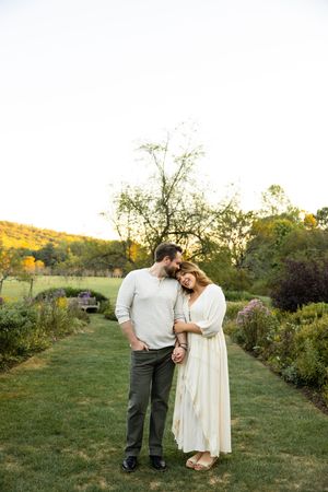 A couple shares a tender moment together in a garden setting at golden hour.