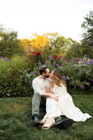 Romantic couple shares intimate moments among vibrant wildflowers in a garden setting during golden hour.