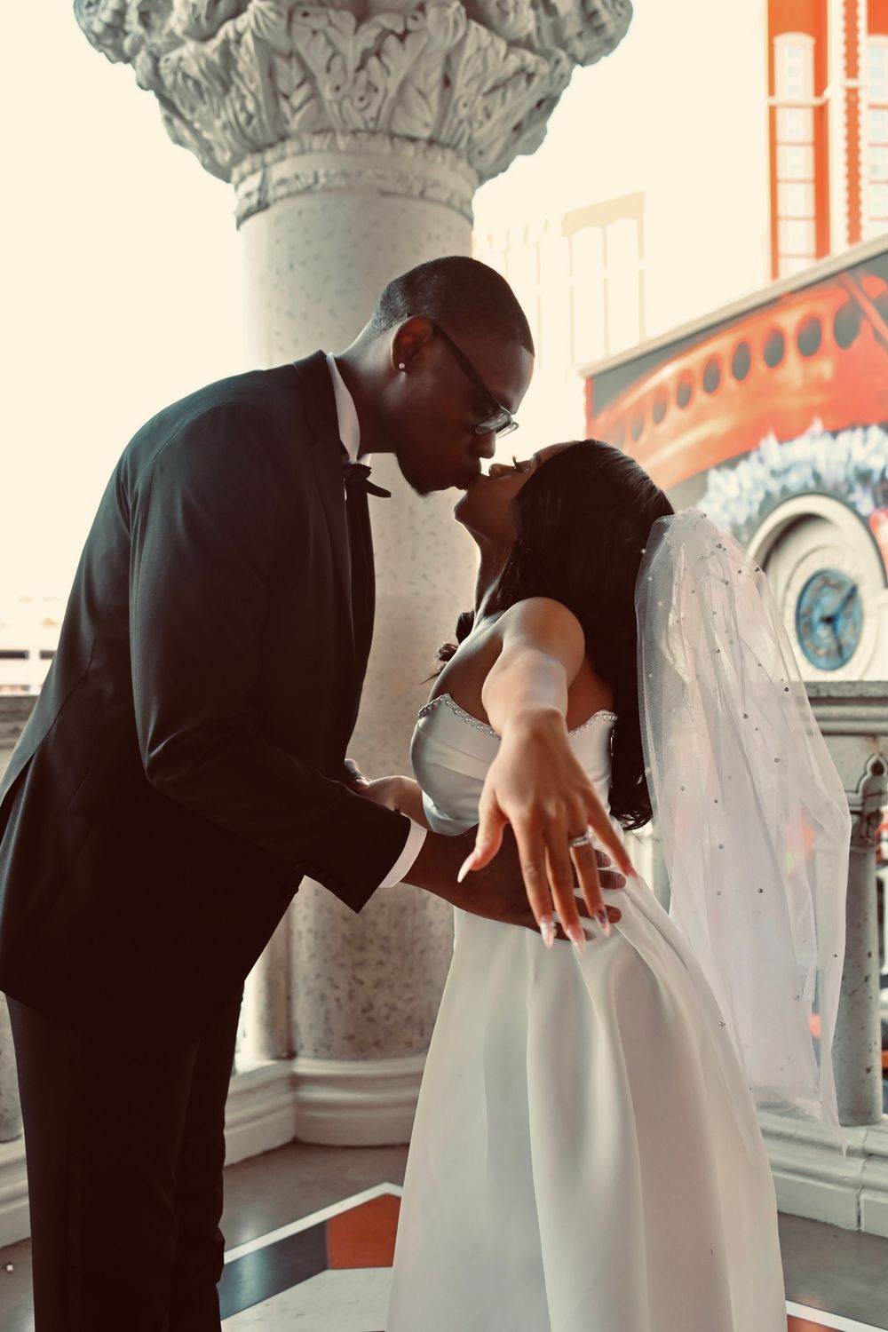 Bride and groom sharing a romantic kiss on a balcony at The Venetian Las Vegas.