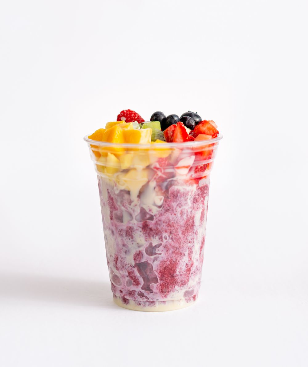 Fresh fruit and yogurt parfait with mixed berries and mango in clear container.
Brand, product photography.