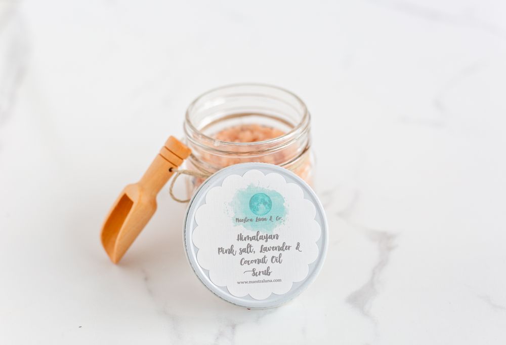 Glass jar with orange wooden spoon and label displayed on white surface.