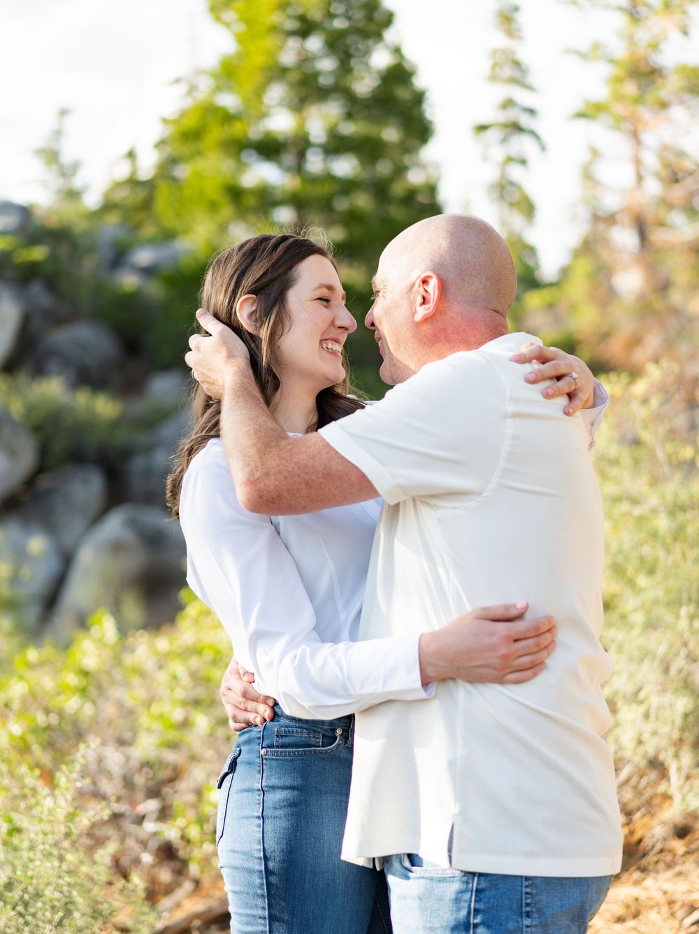 A couple shares joyful moments together outdoors during a sunset photoshoot in a natural setting.