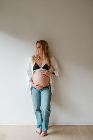 Melissa Stuer Photography Moederschapsfotograaf Moerbeke zwangerschap fotoshoot thuis at home blote buik, jeans, bh -  fotograaf waasland