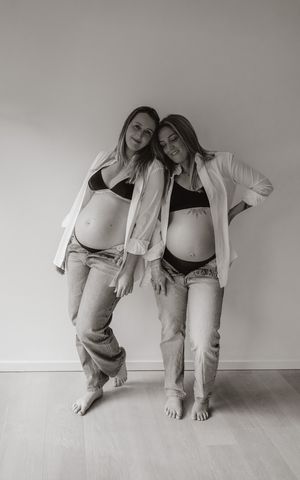 Melissa Stuer Photography Moederschapsfotograaf Moerbeke zwangerschap fotoshoot 2 zussen thuis blote buik, jeans, bh -  fotograaf Lokeren