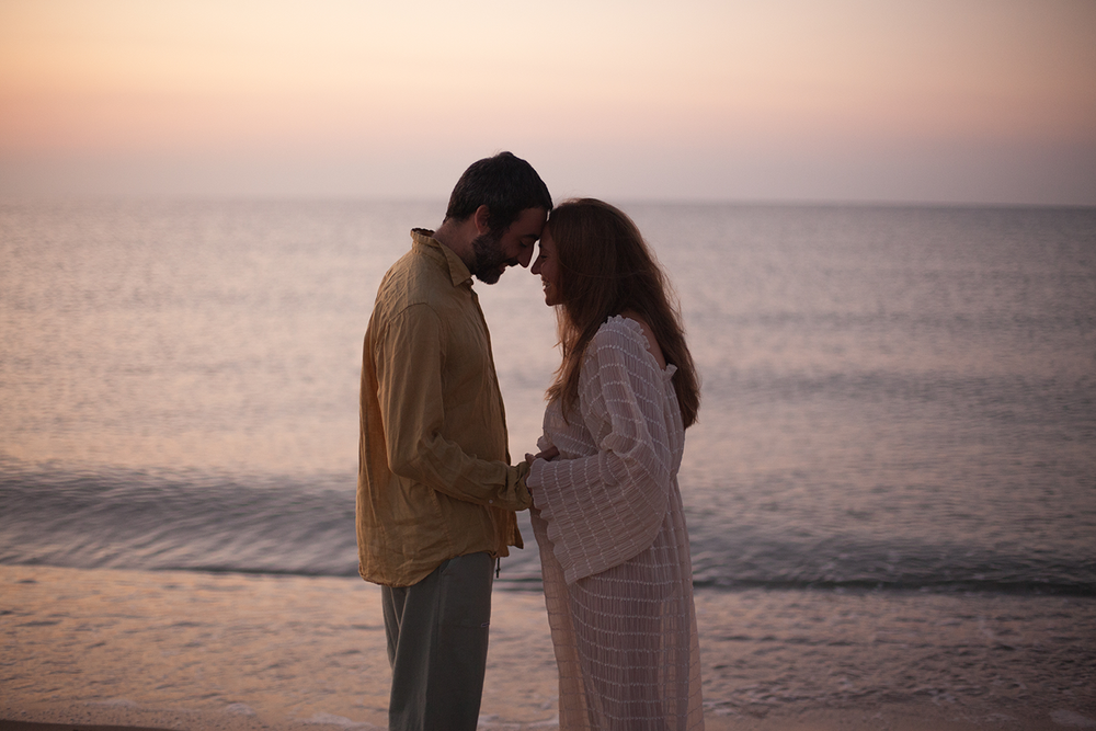 sessione all'alba in Spagna, spiaggia Altafulla, luce calda , mare, amore, maternità, donna incinta, mano sulla pancia, emozione alba