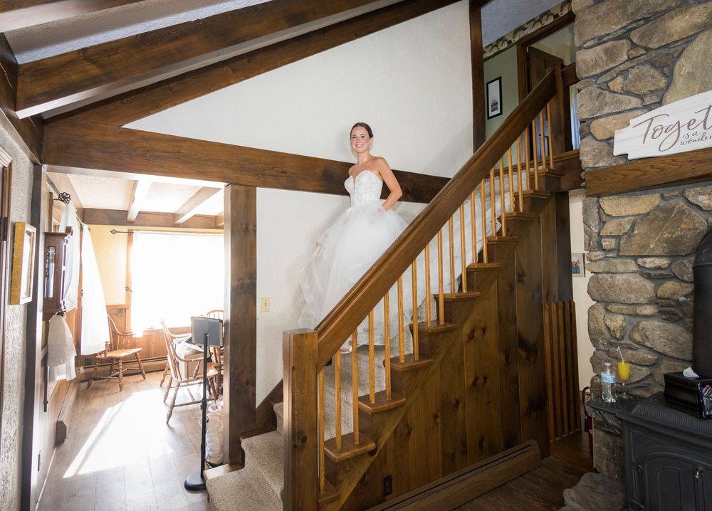 Rustic wooden staircase and stone wall interior of a wedding venue.