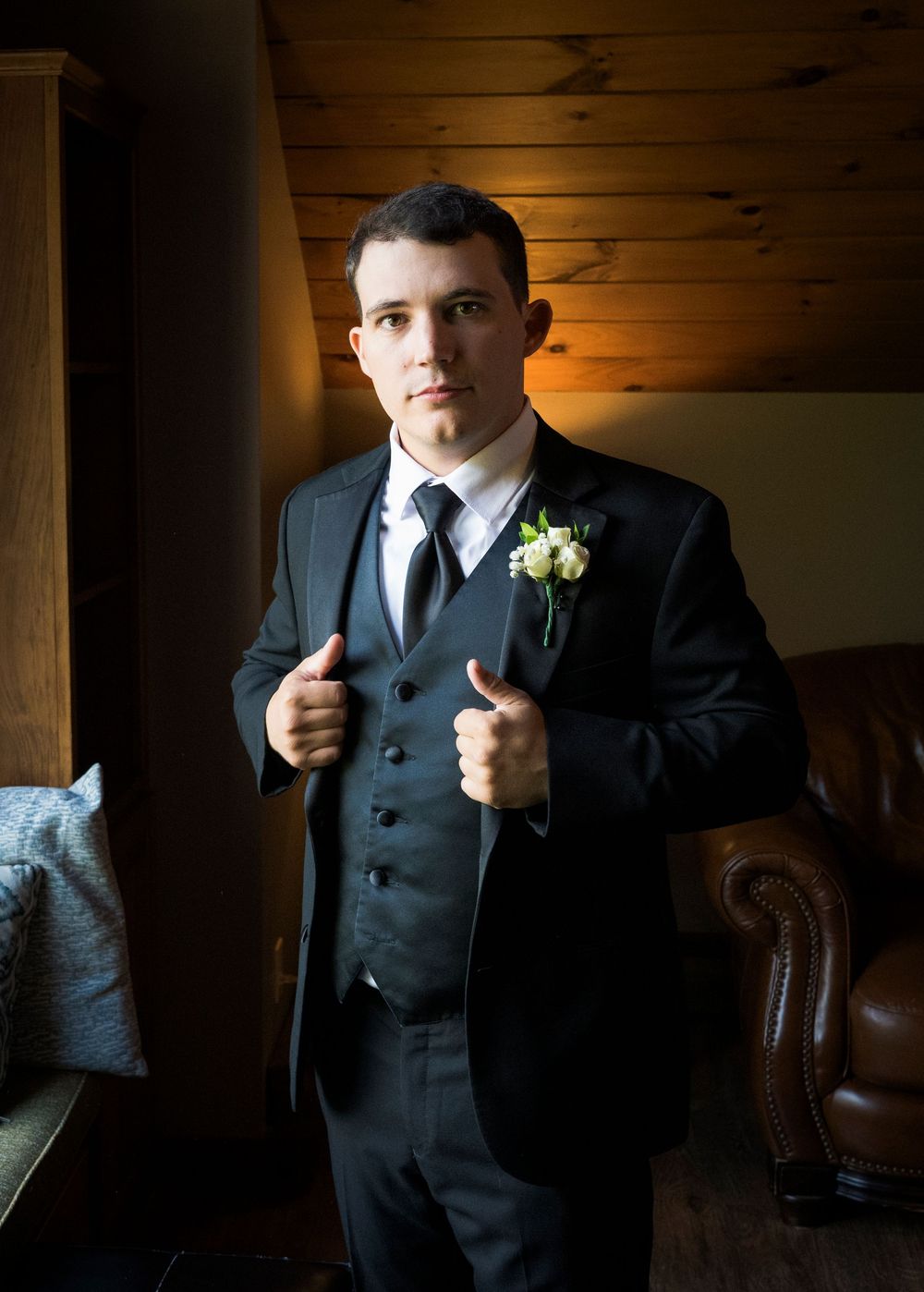 A series of dramatic portraits in dark lighting showing formal attire and a boutonniere.