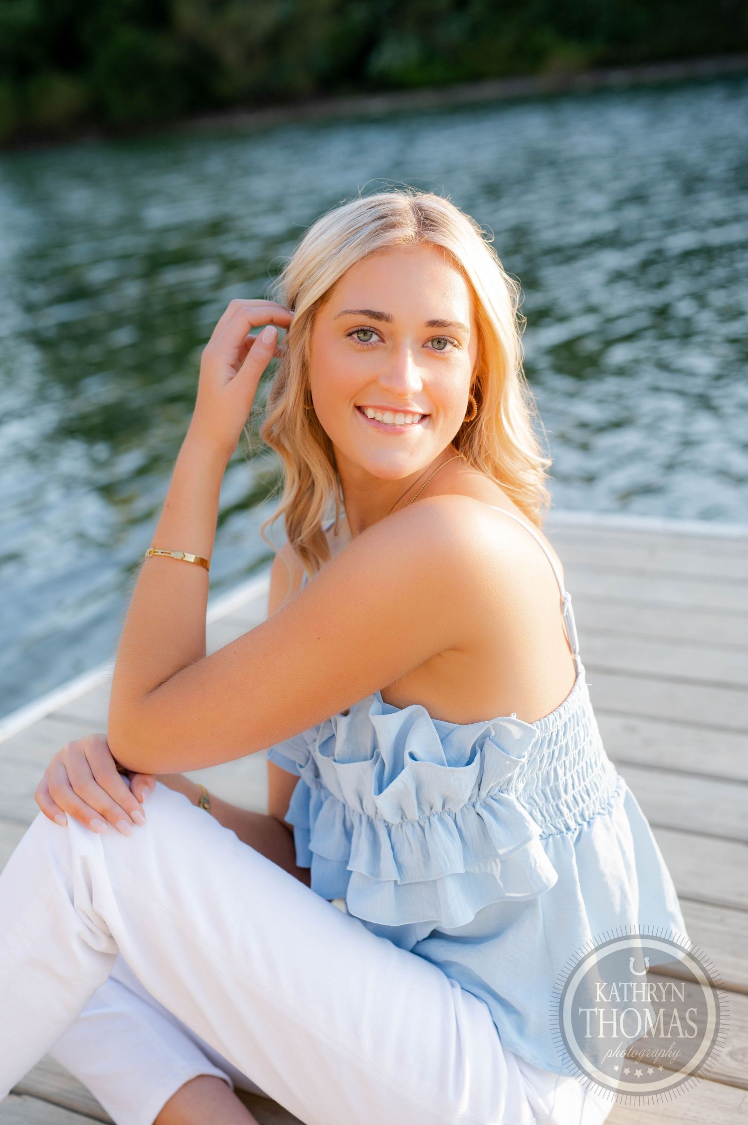 Relaxed dock portrait with light blue top and natural summer styling.