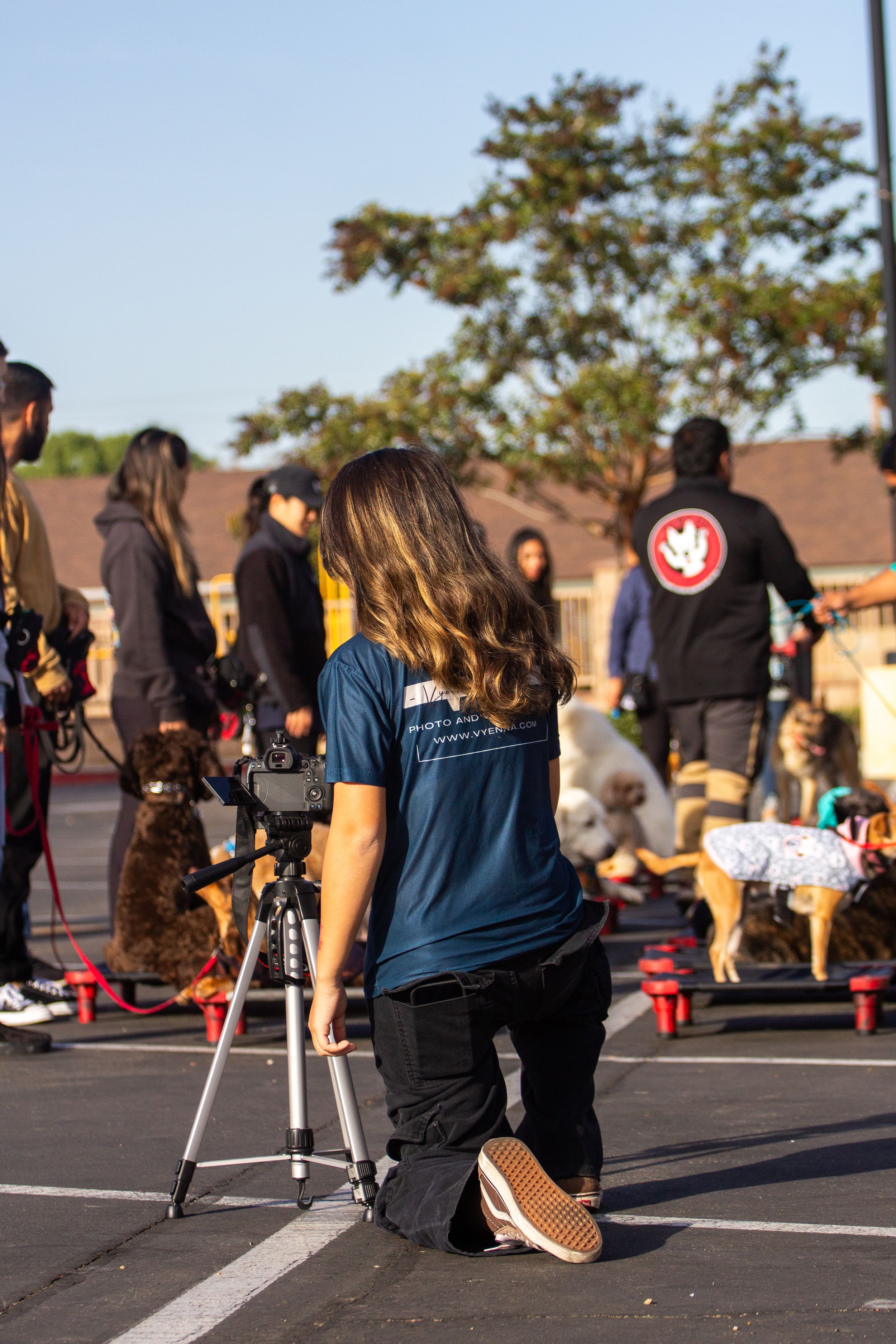 A group of people participate in an outdoor training exercise with safety cones in a parking lot at sunset.