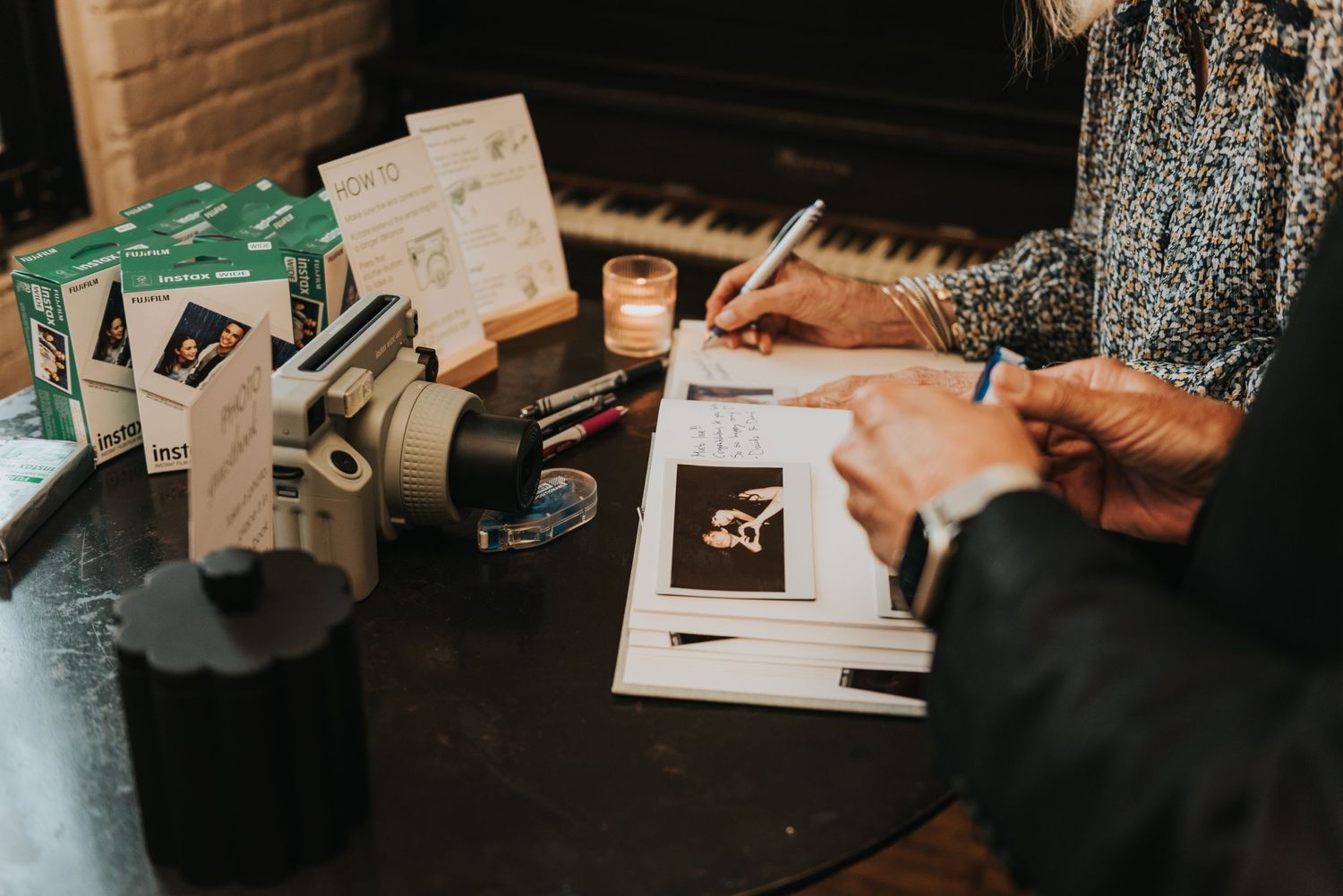 Person writing on papers at desk with coffee cup and notebook in moody lighting setup.