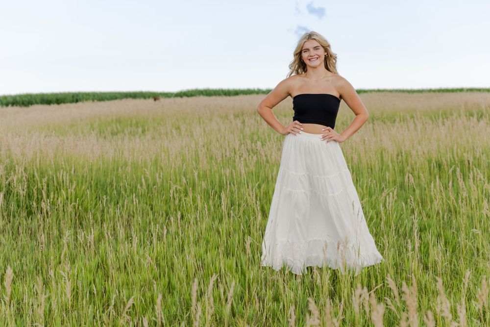 becky katzberg photography senior girl wearing black halter top and white skirt in a grassy field