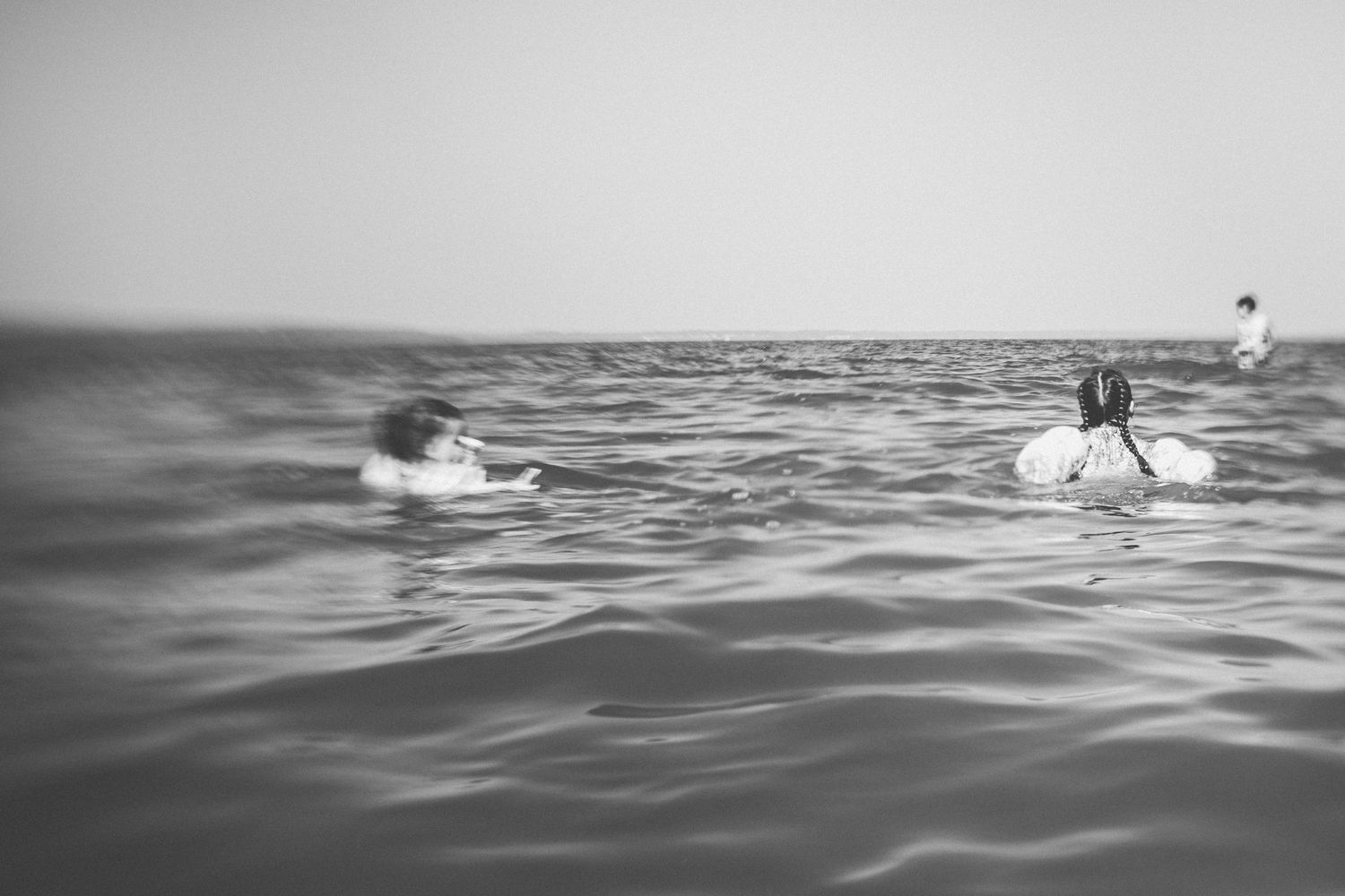 Black and white photo showing children playing in the water.